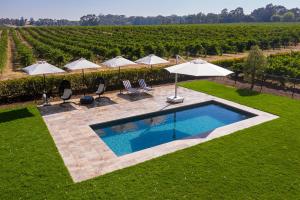 a swimming pool in a yard with umbrellas at Le Mas Barossa in Rowland Flat