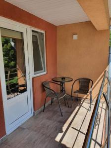 eine Terrasse mit einem Tisch und Stühlen auf dem Balkon in der Unterkunft SergillioHouse in Chişcău