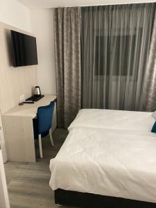 een hotelkamer met een bed en een bureau met een computer bij DM Sobe in Tuzla