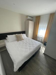 een slaapkamer met een groot wit bed in een kamer bij DM Sobe in Tuzla
