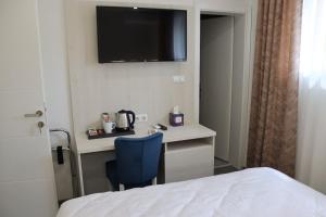 een kamer met een bed en een bureau met een televisie aan de muur bij DM Sobe in Tuzla