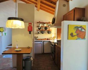Il comprend une cuisine équipée d'une table et d'un réfrigérateur blanc. dans l'établissement MONTE DO SEISSAL by Stay in Alentejo, à Relíquias