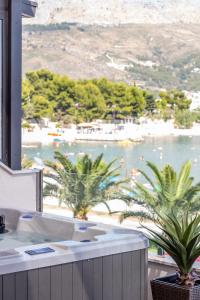 a bathroom with palm trees and a view of a beach at Luxury rooms ''Seven'' in Split