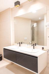 uma casa de banho com um espelho grande e um lavatório em Luxury rooms ''Seven'' em Split