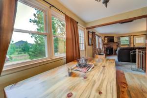 uma mesa de madeira numa sala de estar com janelas em Cascade Mountain Stream em Cascade-Chipita Park