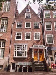 un edificio de ladrillo con una escalera delante de él en 23 SouS, en Ámsterdam