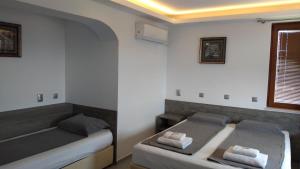 a bedroom with two beds and a window at Guest House Harmony in Veliko Tŭrnovo +50 photos