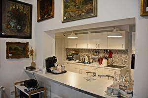 a kitchen with white cabinets and a counter top at Neferprod Apartments - IS - CAM 07 in Timişoara