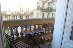 a balcony with chairs and a table and a view of a building at Burdigala Homes - Appart Duffour Dubergier in Bordeaux