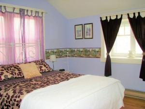 a bedroom with a bed with purple walls and a window at Auberge De Mon Petit Chum B&B in Wakefield