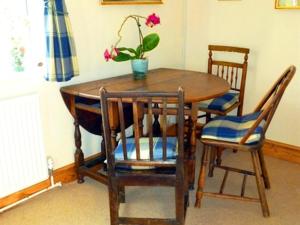 une table en bois avec deux chaises et une plante en pot. dans l'établissement Calne Bed and Breakfast, à Calne