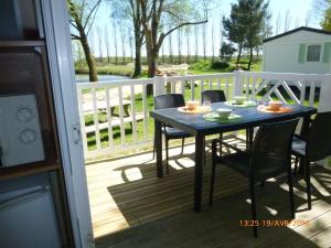 einen Tisch und Stühle auf einer Terrasse mit Aussicht in der Unterkunft Camping Au Clos de Beaulieu in Bossée