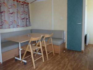 Zimmer mit einem Tisch, Stühlen und einem Sofa in der Unterkunft Camping Au Clos de Beaulieu in Bossée