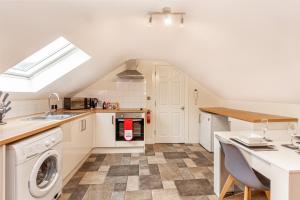 a kitchen with a washer and dryer in a house at Guest Homes - Carriage Court in Worcester