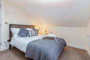 a bedroom with a bed with a table on it at Guest Homes - Carriage Court in Worcester