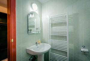 a white bathroom with a sink and a mirror at Panorama Guesthouse in Sighişoara +39 photos