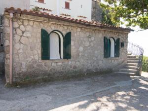 サンタガータ・スイ・ドゥエ・ゴルフィにあるHoliday Home Nulla di Troppo by Interhomeの緑の窓と階段のある石造りの建物