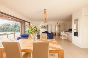 comedor y sala de estar con mesa de madera y sillas en Casa Fiumu Oso, en San-Gavino-di-Carbini