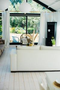 a living room with white furniture and a large window at Vakantiewoning Loft Lisse - SAUNA - Beach - Keukenhof in Lisse