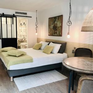 a bedroom with a large bed and a table at Chambres d'hôtes CASA MUSA - NICE in Nice