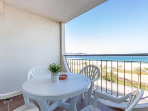una mesa blanca y sillas en un balcón con vistas al océano en Apartment Bahia I by Interhome, en Empuriabrava