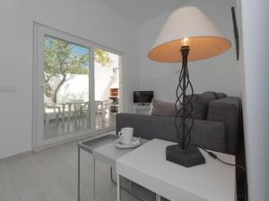 a living room with a table with a lamp on it at Casa Santos Nicolau in Setúbal