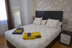 una camera da letto con un letto e due asciugamani di Apartamento Turístico Casa Museo Parking y Cargador a Mérida