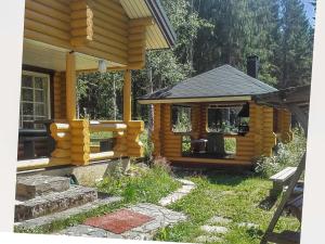 a log cabin with a gazebo in the yard at Holiday Home Pikku harrila by Interhome in Huuhanaho