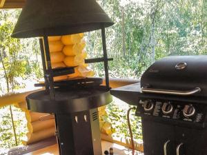 a kitchen with a stove and a grill with a lamp at Holiday Home Pikku harrila by Interhome in Huuhanaho