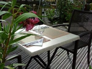 una mesa con vasos y servilletas en el patio en Chambres d'hôtes Au Clos de Beaulieu en Bossée