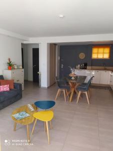 een woonkamer met een bank en een tafel en stoelen bij le cytharis in La Ciotat