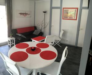 a living room with a red and white table and chairs at Chalet orange naturiste la Jenny in Le Porge