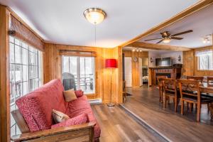 a living room with a couch and a dining room at Le Chalet Relax du Lac St-Tite in Saint-Tite-des-Caps