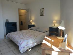 ein Schlafzimmer mit einem Bett und einem Tisch mit einer Lampe in der Unterkunft Au Figuier des Cévennes in Saint-Germain-de-Calberte