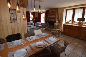 une salle à manger avec une table et un piano dans l'établissement VAUJANYLOCATIONS - Chalet Louise, à Vaujany