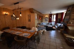 sala de estar con mesa y sofá en VAUJANYLOCATIONS - Chalet Louise, en Vaujany