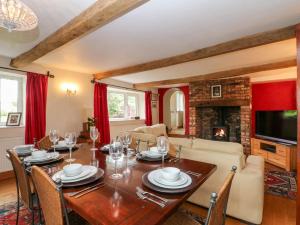 a dining room with a table and a fireplace at Moody House Farm in Chorley
