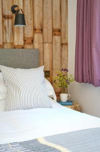 Fonthill Bishop的住宿－Bird & Carter Fonthill，一张带黑白枕头和紫色窗帘的床