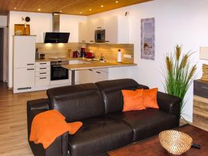 a living room with a couch and a kitchen at Holiday Home Heide by Interhome in Altefähr