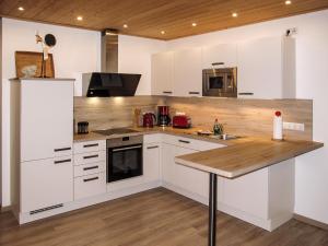 a kitchen with white cabinets and a wooden counter top at Holiday Home Heide by Interhome in Altefähr