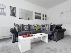 a living room with a couch and a coffee table at Live in Leeds Grange Apartments in Leeds