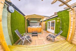 a room with a green wall with chairs and a tub at Thomas Wright House in Byers Green