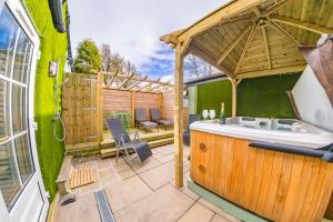 a garden with a hot tub and a wooden pergola at Thomas Wright House in Byers Green