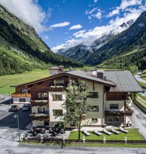 an image of a hotel with mountains in the background at Hotel Möderle in Sankt Leonhard im Pitztal