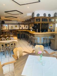 ein Restaurant mit Tischen und Stühlen und eine Bar in der Unterkunft Landgasthaus Jägerhof in Büren