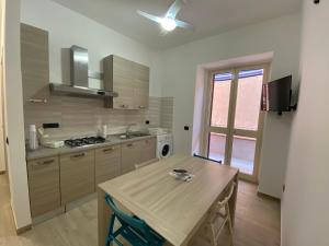 a kitchen with a wooden table and a sink at Casa Vacanze Lungomare Pietrenere Pozzallo in Pozzallo