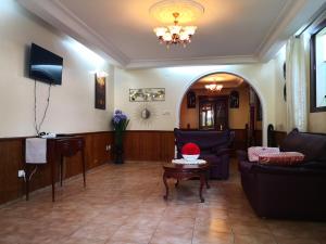 sala de estar con sofá y mesa en Joli jardin en ville, en Yaoundé