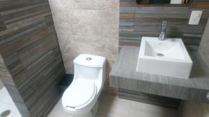 Un baño con un inodoro blanco y un lavabo. en Hotel Central, en San Luis Potosí 11 fotos más