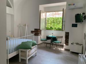 a bedroom with a bed and a table and a window at Catania Centro Storico in Catania