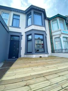 a house with a wooden deck in front of it at Kensington Suite Sasco Apartments in Blackpool